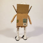Sculpture bonhomme en carton, jambes blanches et marquage 59 sur la boîte