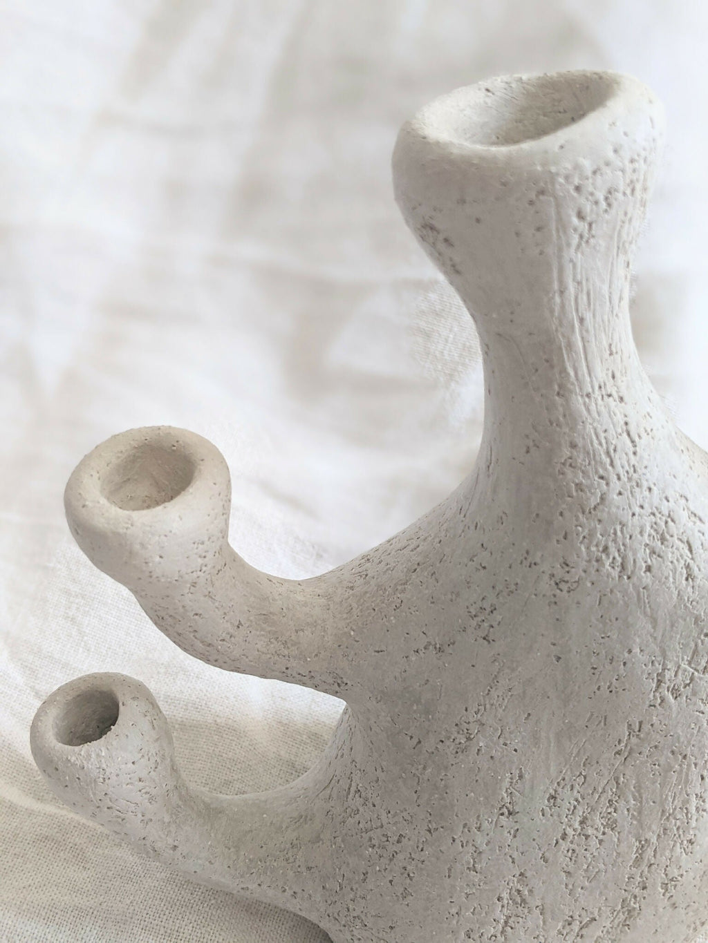 Vase sculpture corail beige en céramique, gros plan sur les ouvertures et la base