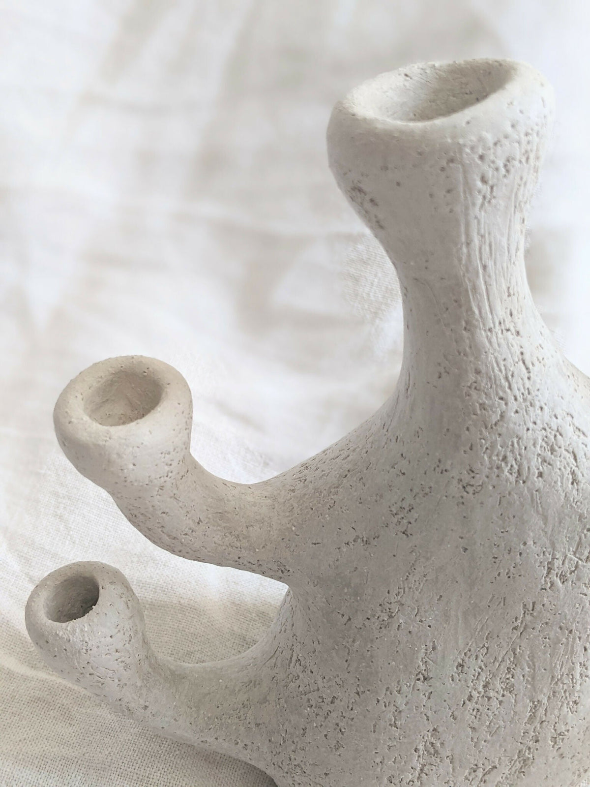 Vase sculpture corail beige en céramique, gros plan sur les ouvertures et la base