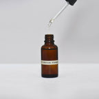 Flacon de sérum visage en verre ambré avec pipette déversant du liquide