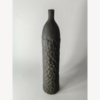 Soliflore sculpté noir en forme de bouteille, finition mate texturée, vue 3/4.