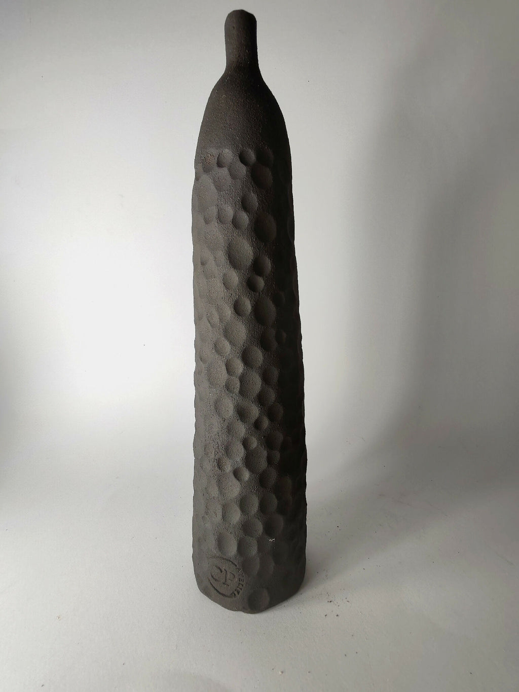 Soliflore sculpté noir, relief en pastilles sur la face, vue de profil.