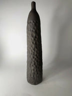 Soliflore sculpté noir, relief en pastilles sur la face, vue de profil.