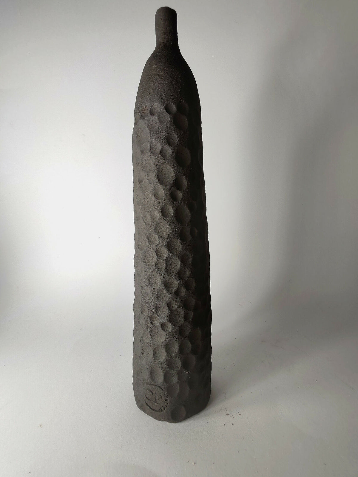 Soliflore sculpté noir, relief en pastilles sur la face, vue de profil.