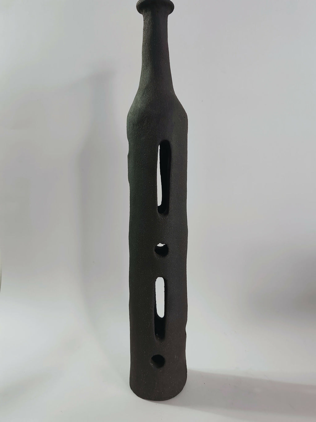 Sculpture soliflore noir en forme de bouteille ajourée de fentes