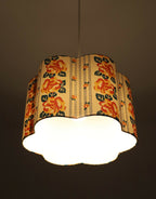 Abat-jour forme fleur en tissu crème à fleurs orange, lumière diffusée vers le bas.
