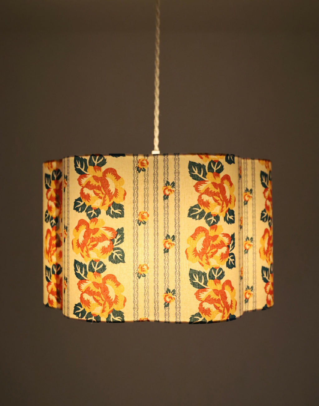 Abat-jour forme fleur en tissu crème, fleurs orange, feuillages verts et rayures chaînettes.