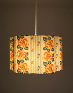 Abat-jour forme fleur en tissu crème, fleurs orange, feuillages verts et rayures chaînettes.
