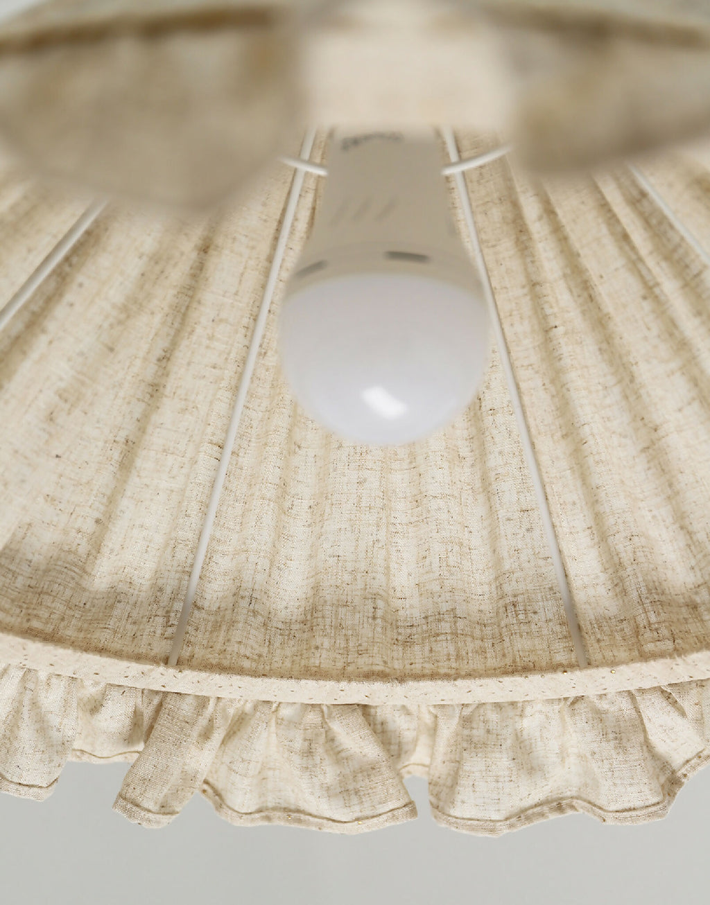 Intérieur de l’abat-jour conique en lin et coton beige à volant froncé