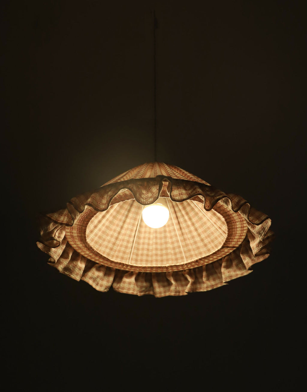 Suspension conique à petits carreaux, volant froncé et ouverture centrale pour la lampe.