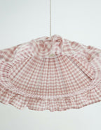 Abat-jour conique en tissu à petits carreaux rose, volants froncés et couture centrale.