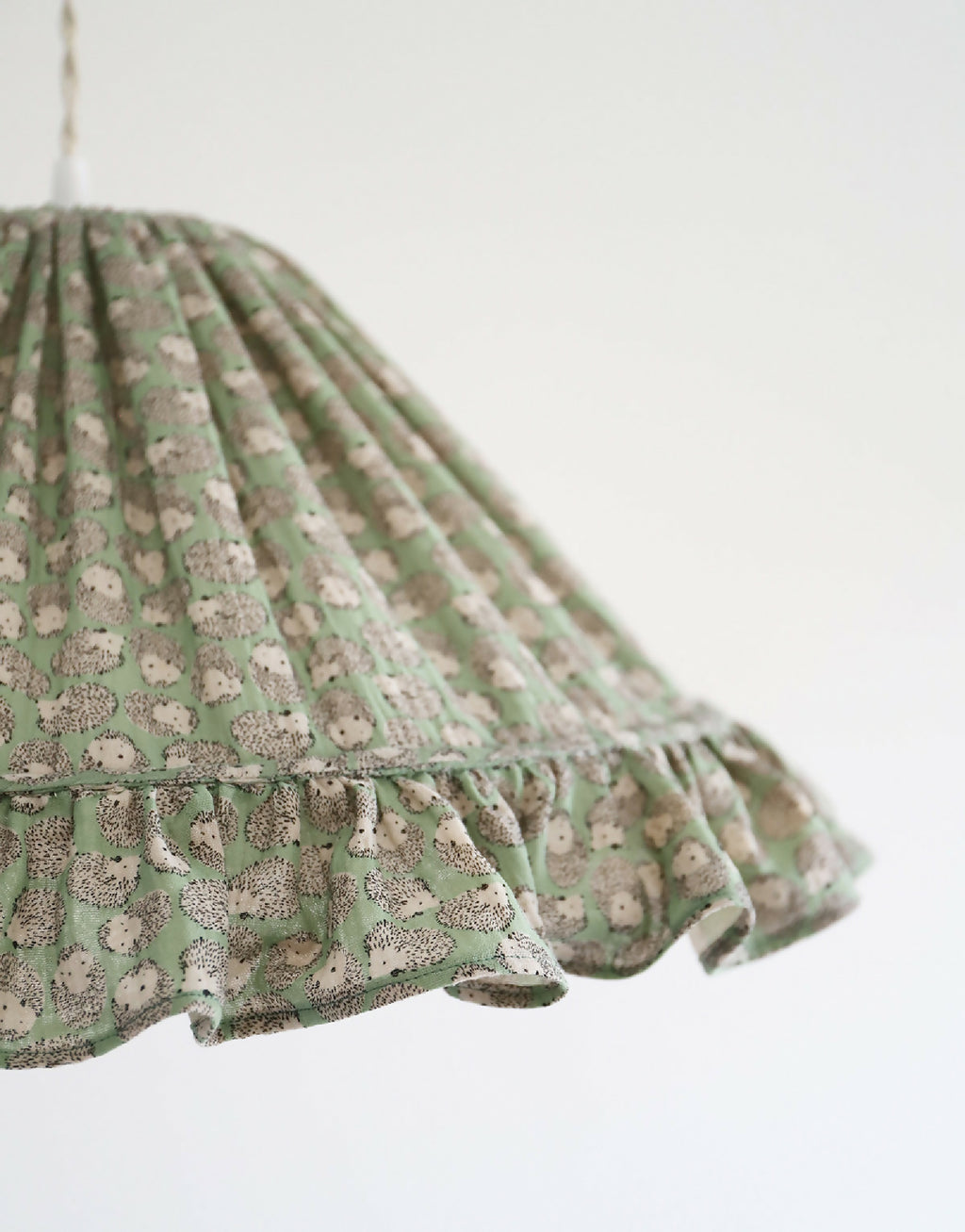 Suspension conique en tissu vert clair, plis et motifs de petits hérissons