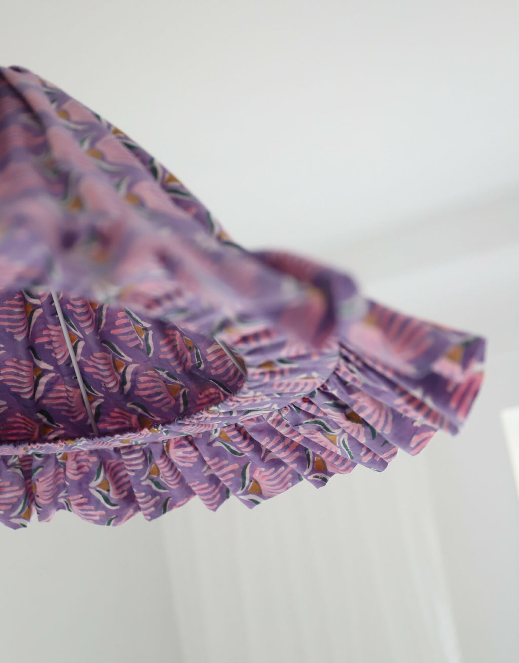 Suspension conique mauve à volants, motif coquillages visible sur la partie latérale