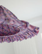 Suspension conique mauve à volants, motif coquillages visible sur la partie latérale