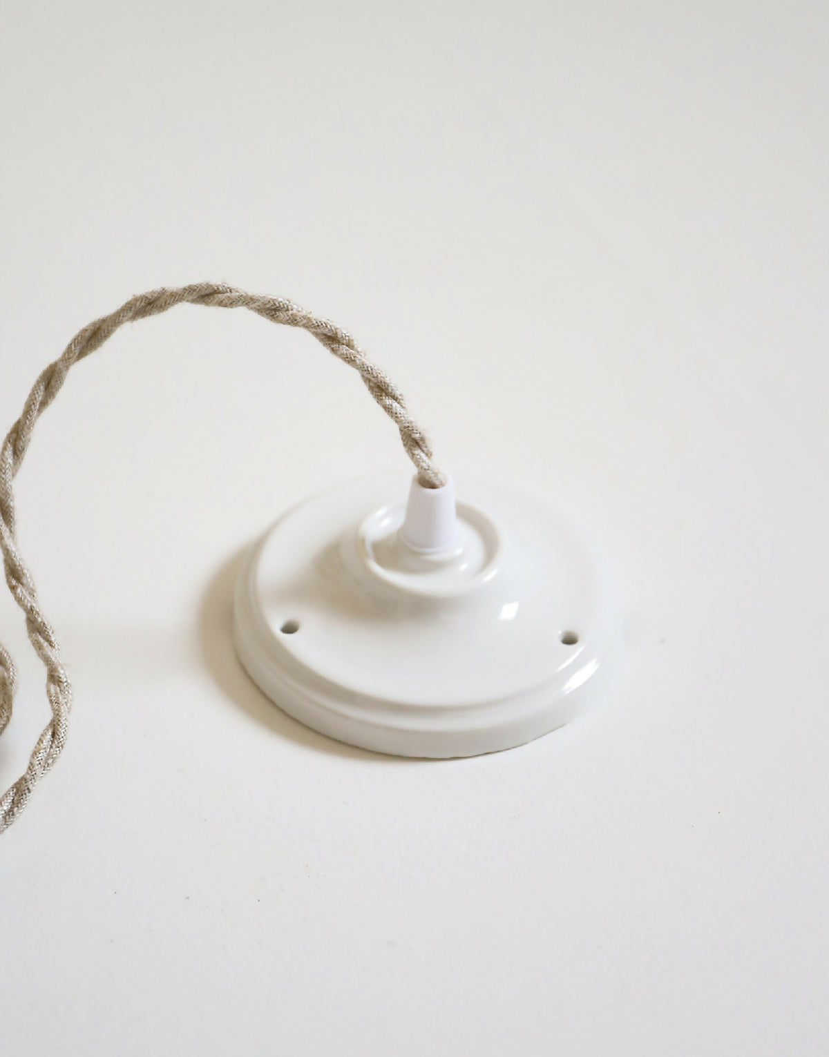 Support de suspension au plafond blanc avec cordelette et douille de fixation.