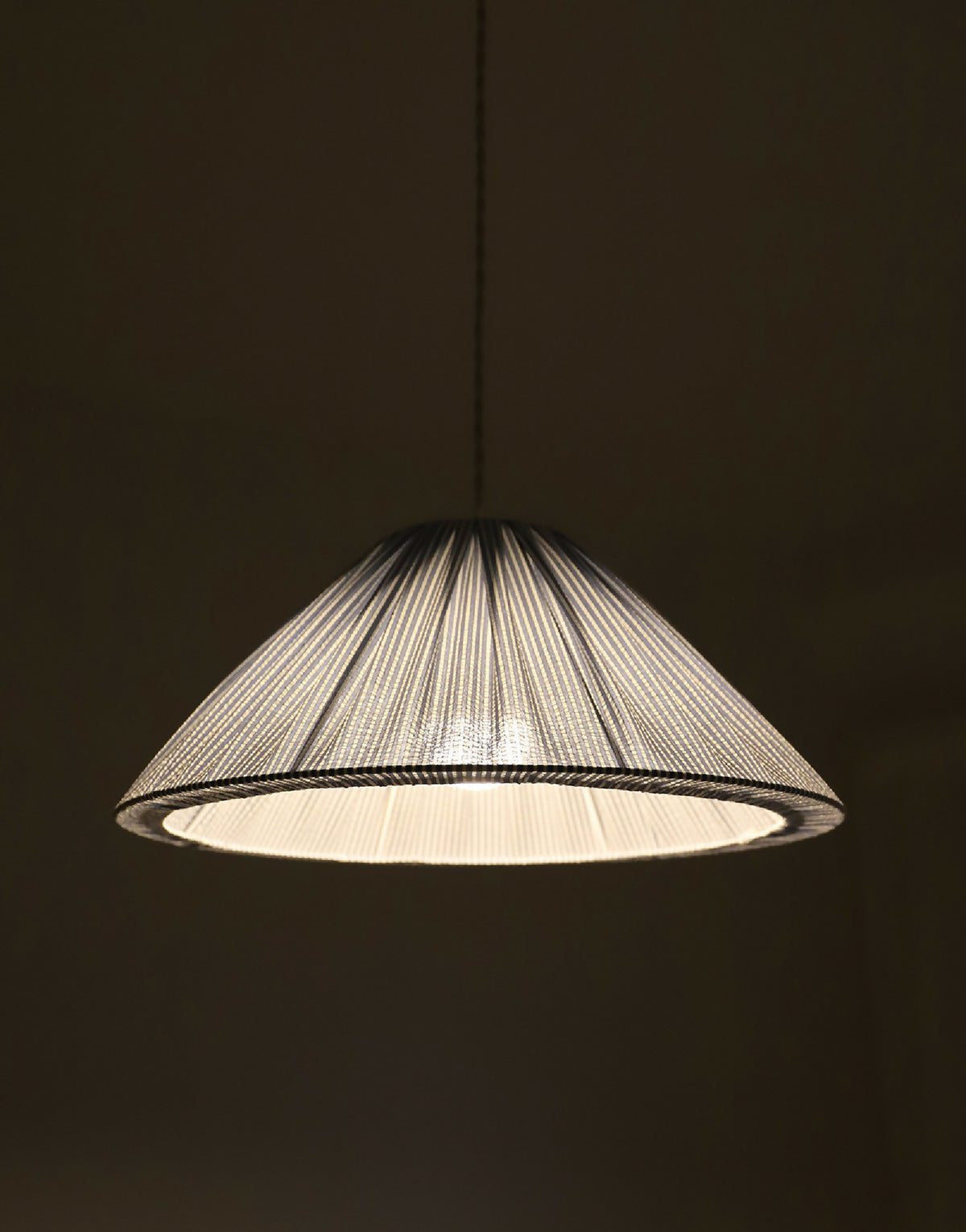 Suspension conique à fines rayures dorées, abat-jour illuminé par dessous.