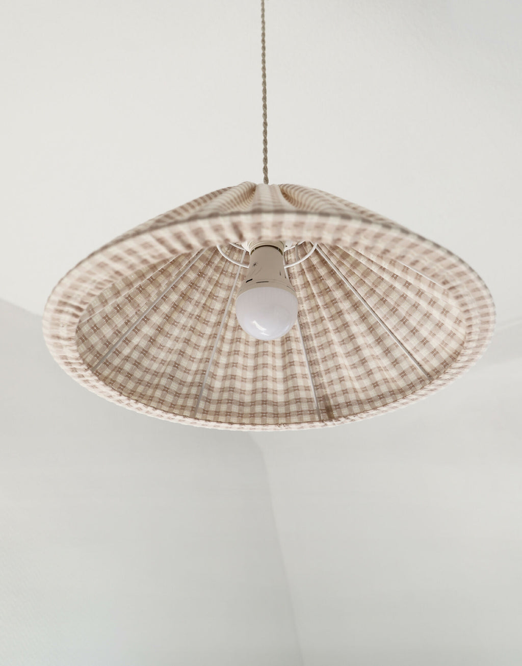 Suspension conique vichy beige clair, petits carreaux, douille blanche au centre.