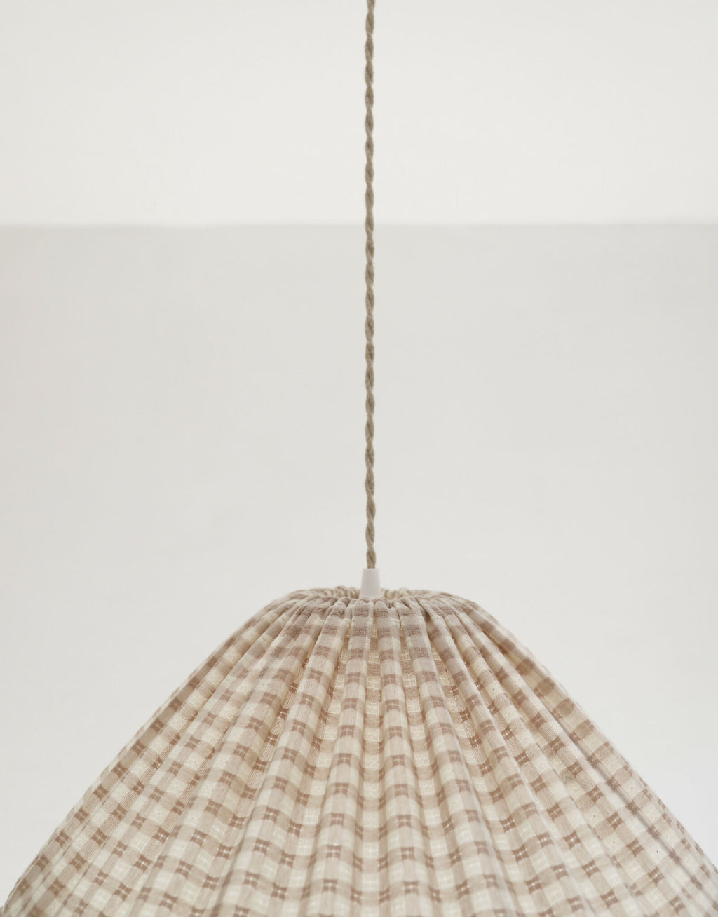 Suspension conique vichy beige clair, petits carreaux, cordon de suspension visible.