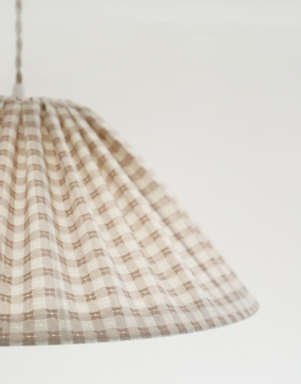 Suspension conique vichy beige clair, petits carreaux, pan de tissu plissé.