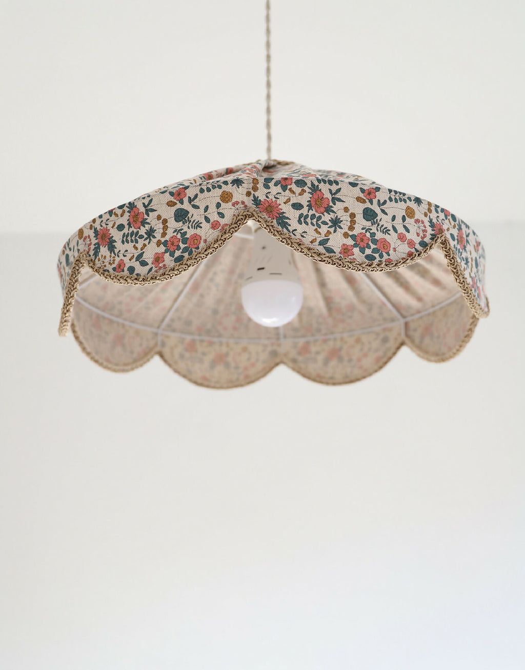 Abat-jour suspension festonné, vue de face avec ampoule et intérieur clair visible.