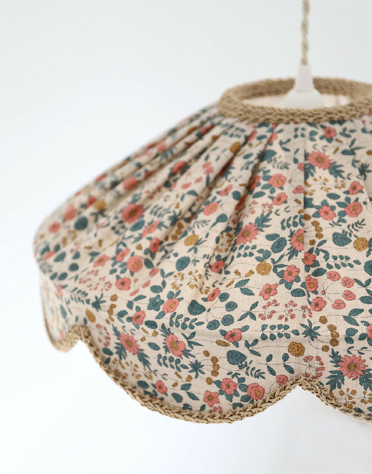 Abat-jour suspension festonné, gros plan sur les plis du tissu floral multicolore.