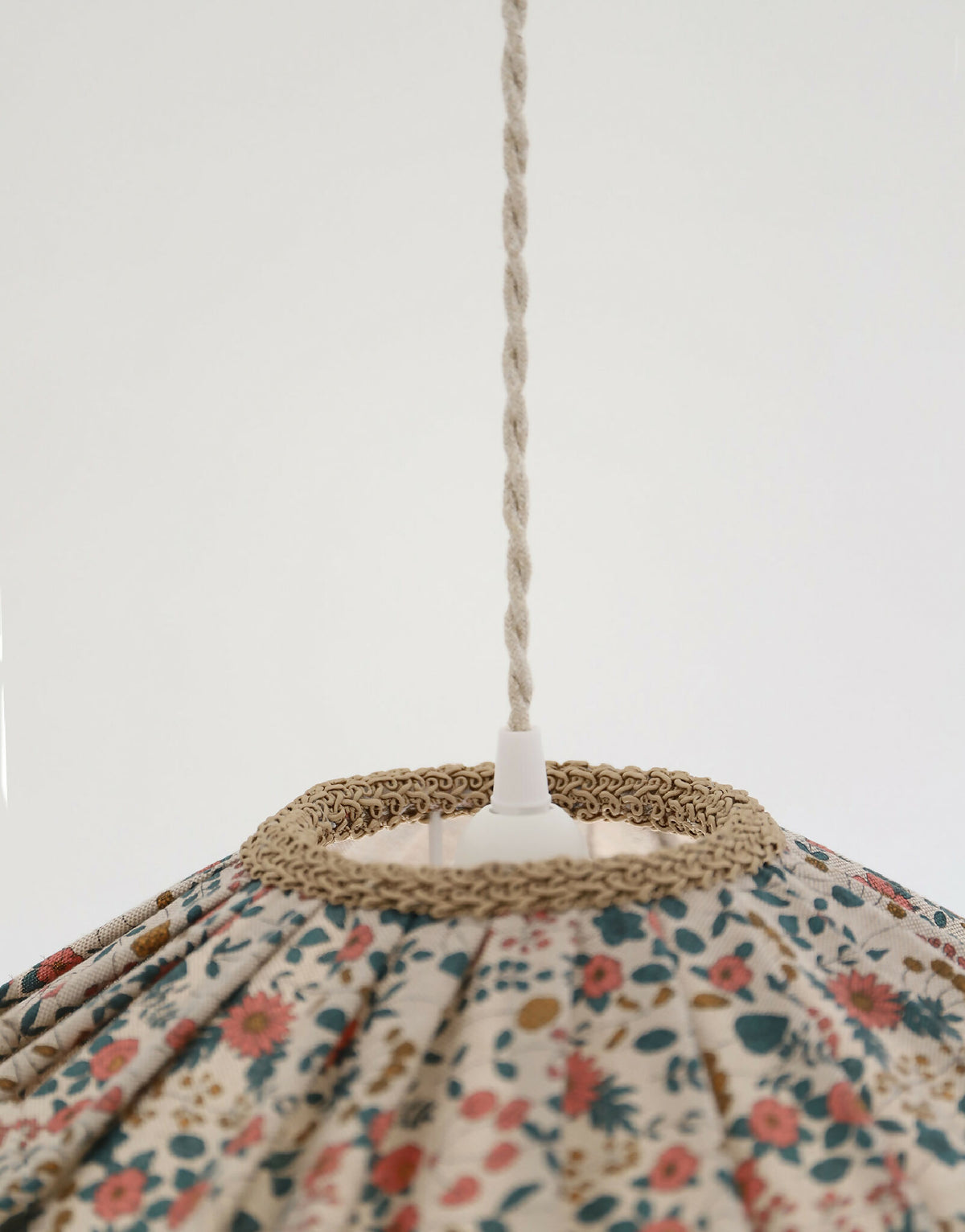 Suspension de l’abat-jour : cordelette en haut et bord festonné en tissu beige.
