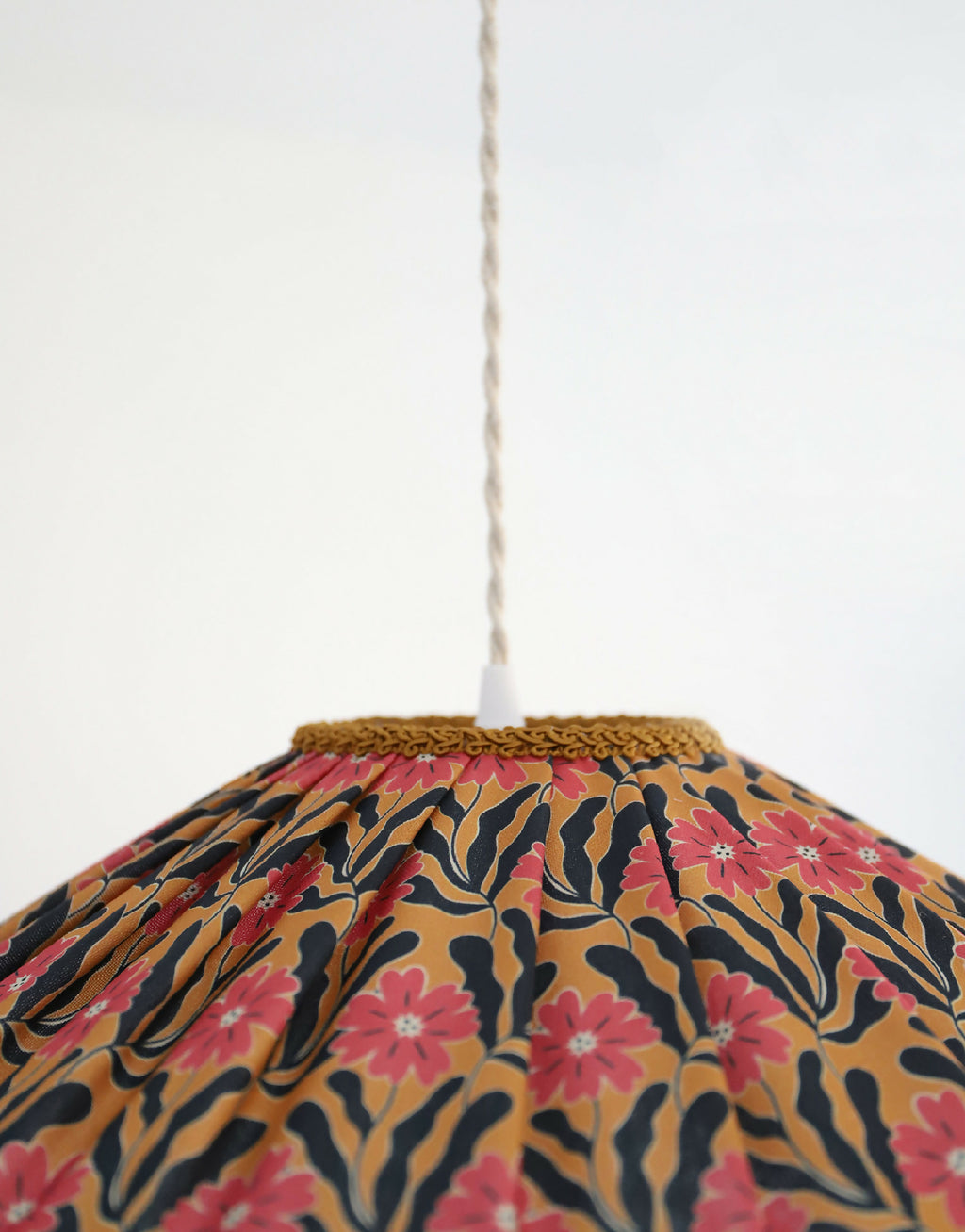 Abat-jour de suspension festonné en tissu floral Goa, motif roses, bord tressé doré.