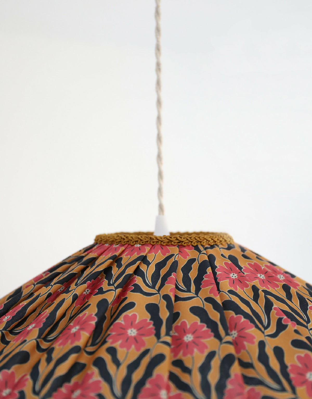 Abat-jour de suspension festonné en tissu floral Goa, motif roses, bord tressé doré.