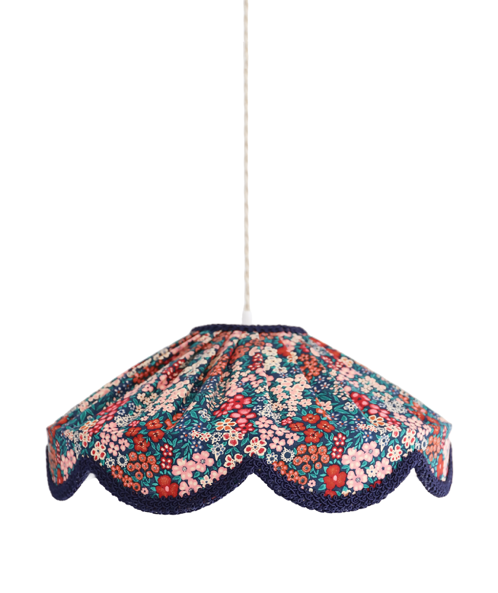 Suspension abat-jour festonné en tissu floral mille fleurs, bord bleu marine foncé.