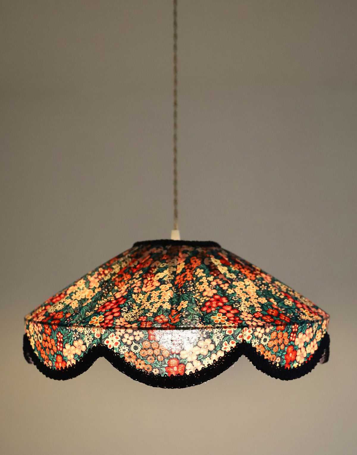 Suspension abat-jour en tissu floral mille fleurs, motif dense multicolore, bord festonné.