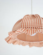 Zoom suspension dôme vichy orange et blanc, volants et couture au centre.