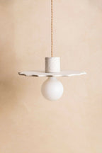 Suspension au diffuseur sphérique blanc, plateau irrégulier en finition sable.