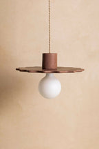 Suspension au diffuseur sphérique blanc, support cylindrique brun et plateau ajouré.