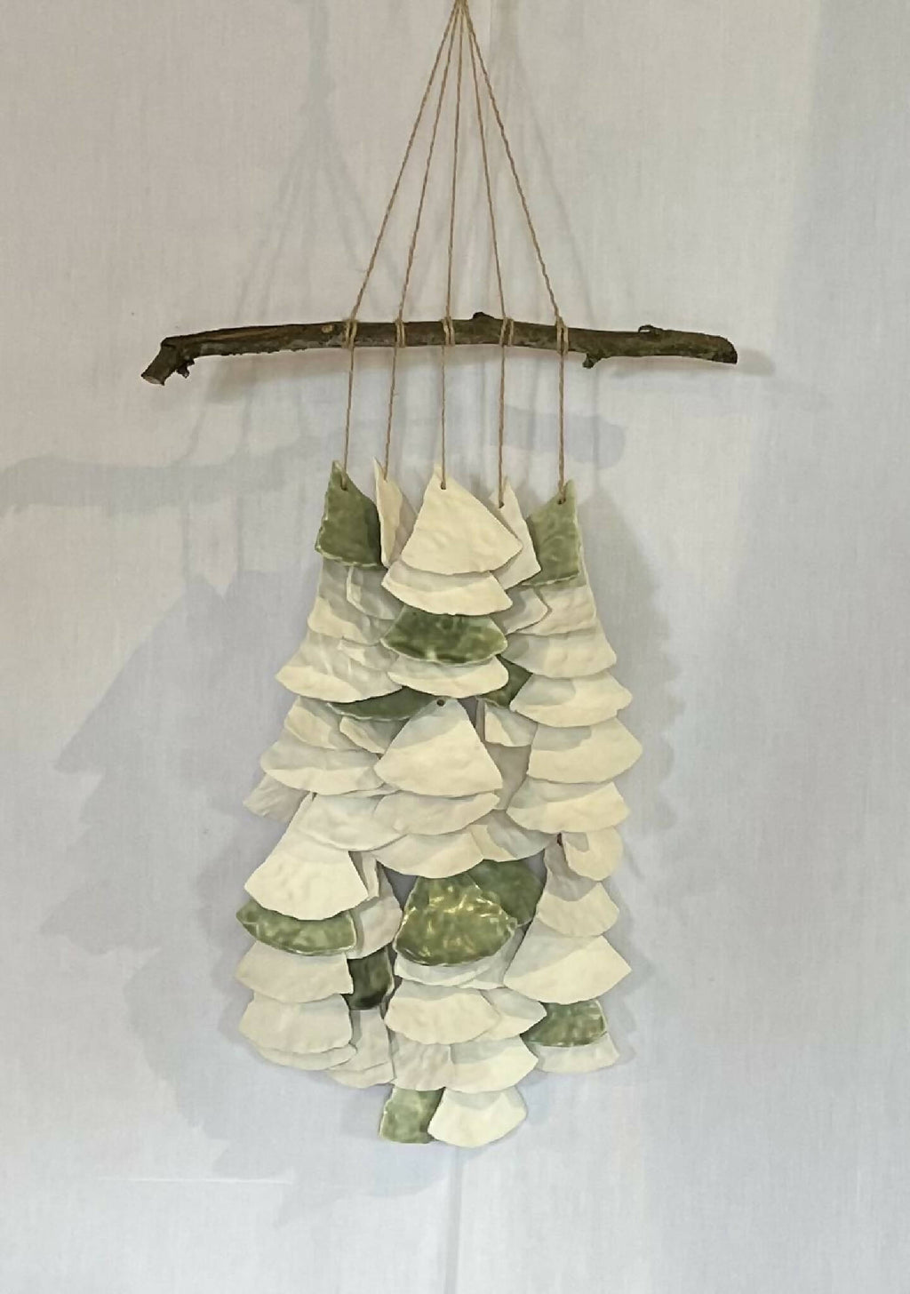 Décoration murale suspendue : barres en bois et clochettes en papier blanc et vert