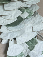 Superposition de clochettes en papier blanc et vert, détail rapproché avec cordelettes