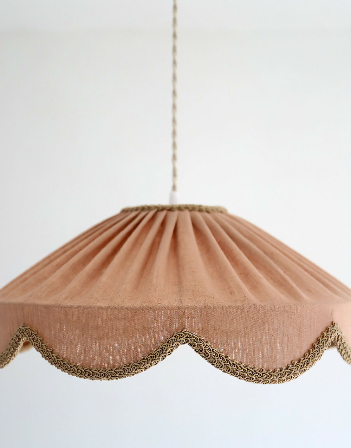 Abat-jour suspendu en lin beige rosé, forme conique froncée et bord festonné doré