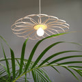 Suspension fleur 55 cm en métal beige, anneau ajouré et ampoule blanche allumée.