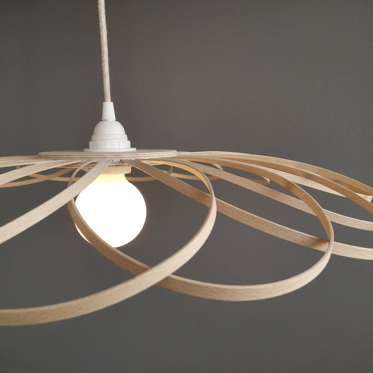 Suspension fleur en métal beige, vue de côté : branches incurvées et douille blanche.