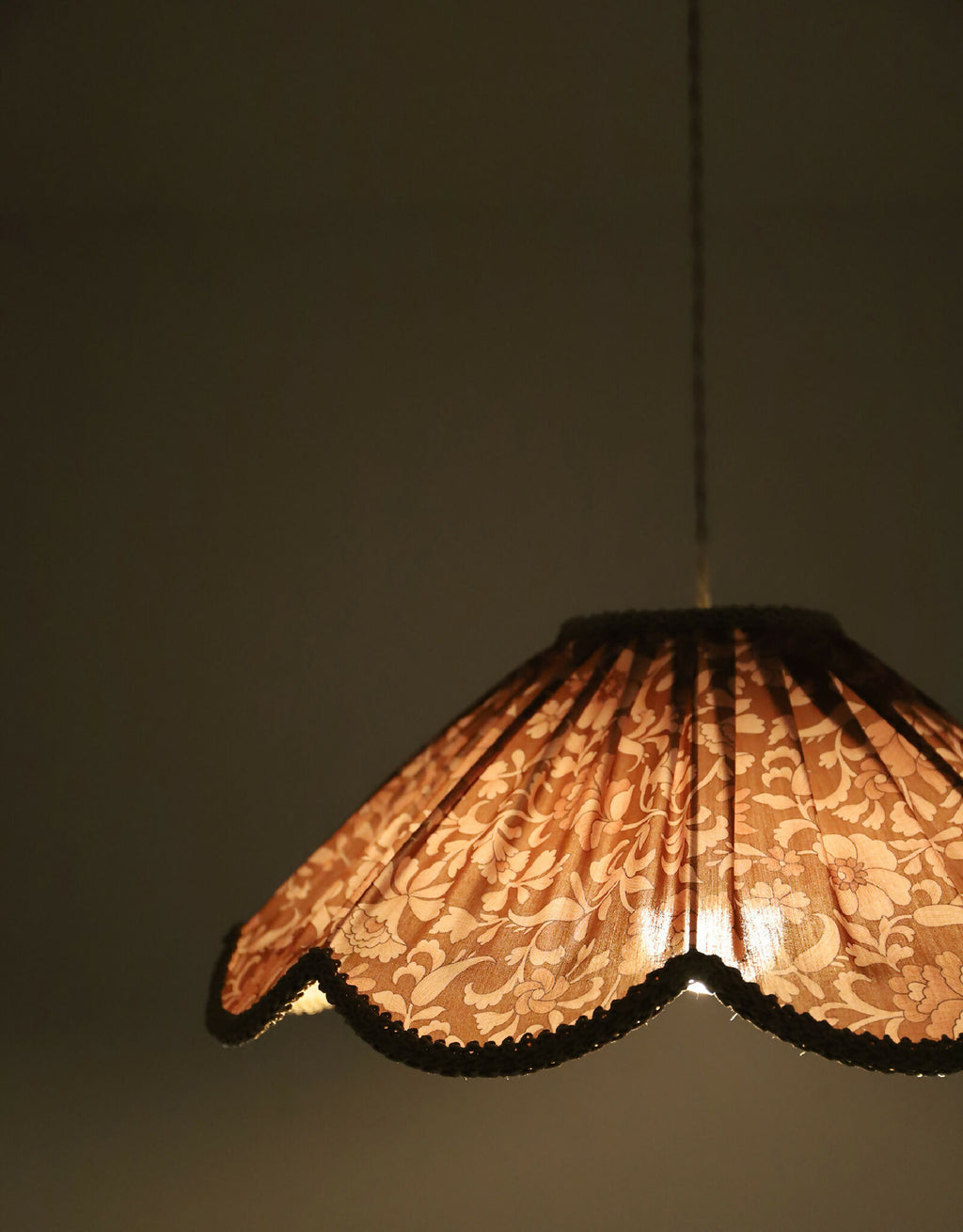 Suspension florale orange, gros plan sur le motif de fleurs et le bord en dentelle.