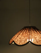 Suspension florale orange, gros plan sur le motif de fleurs et le bord en dentelle.