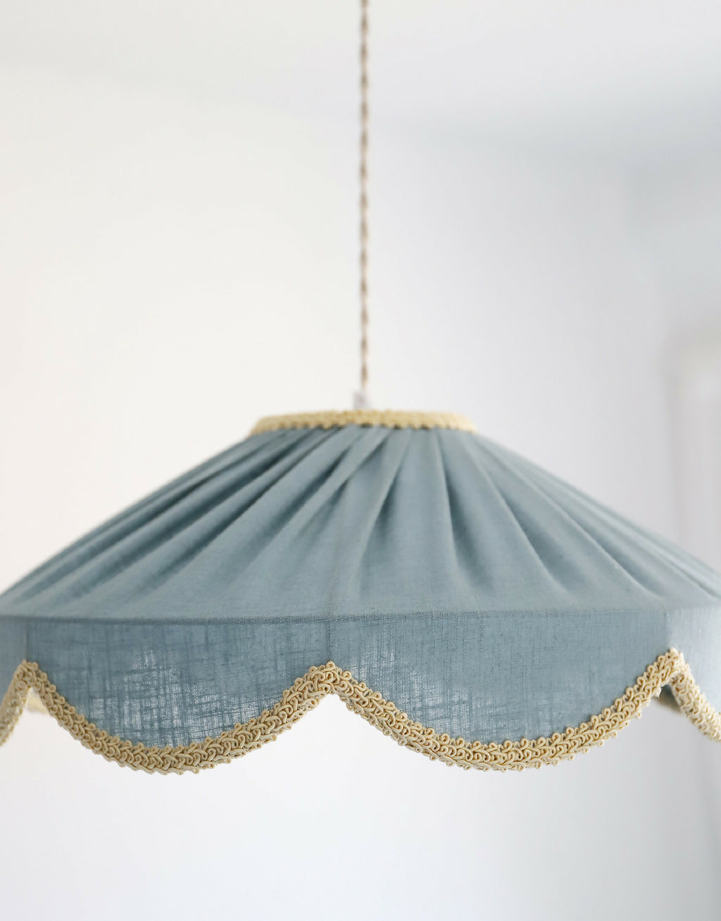 Suspension en forme florale bleu minéral, bordure dorée ondulée sur l’ourlet