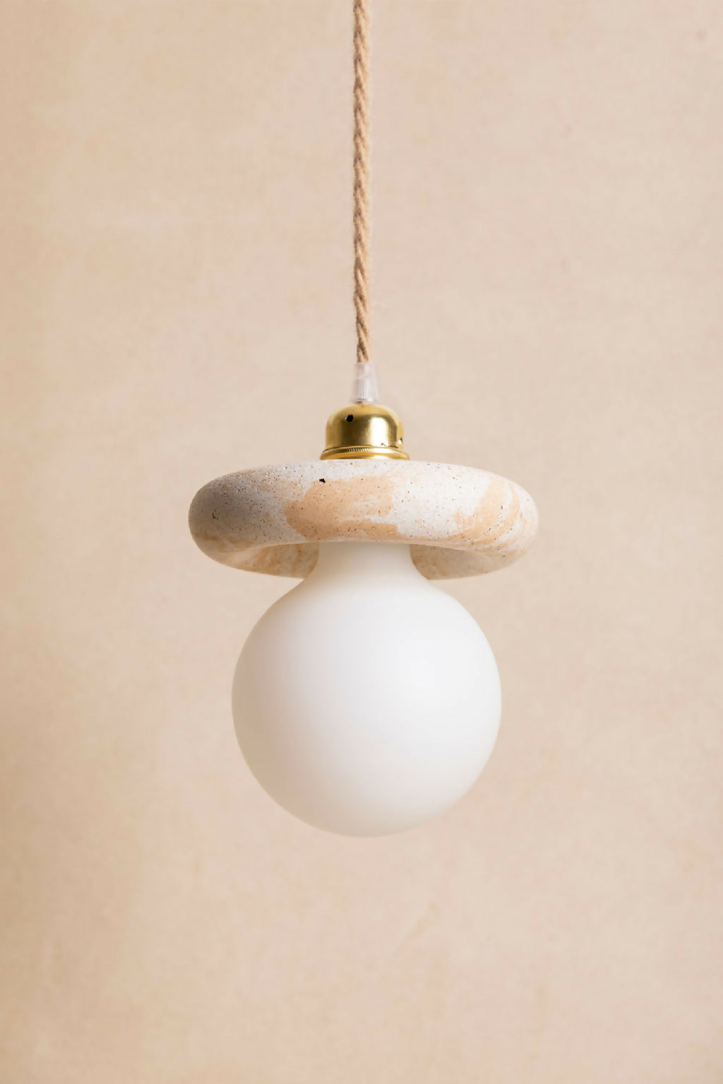 Suspension : abat-jour beige rosé texturé, diffuseur blanc, capuchon laiton et câble torsadé