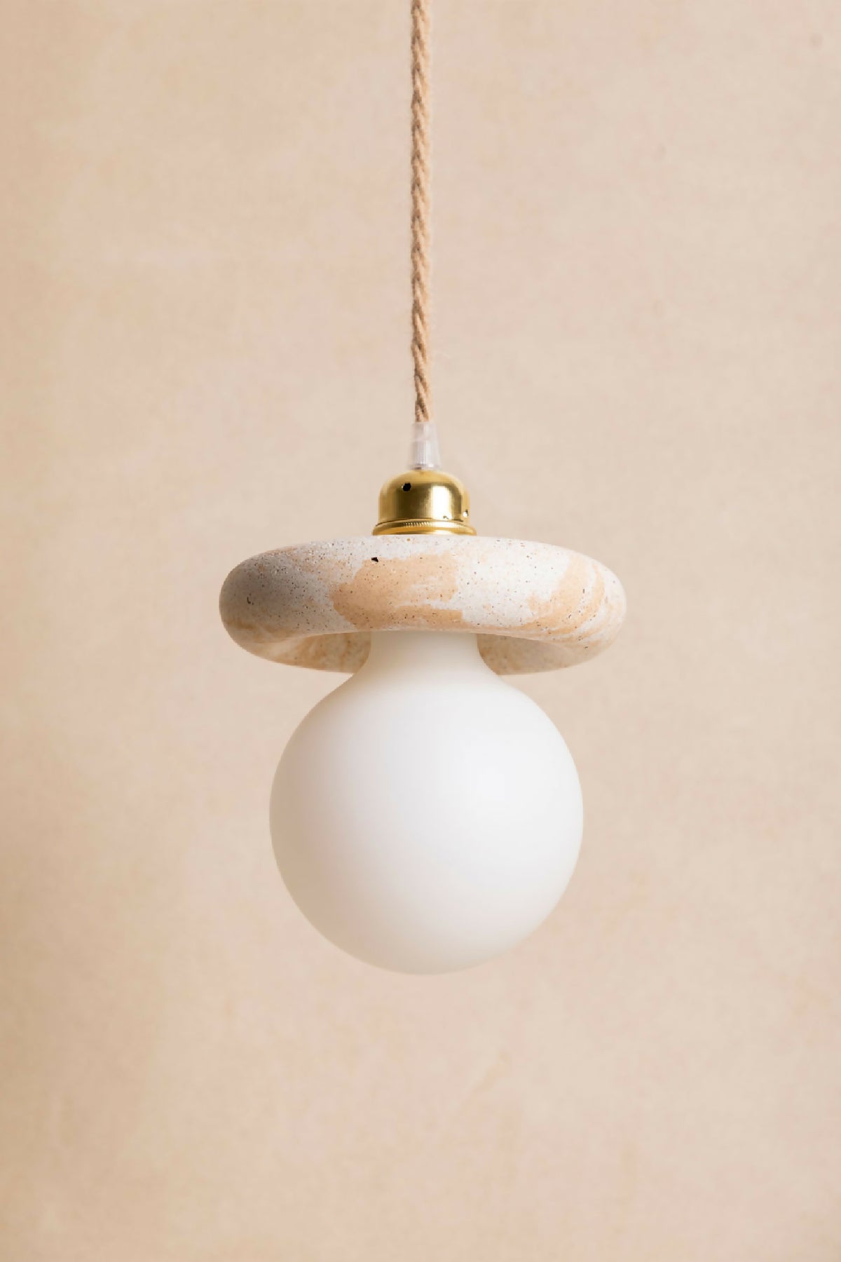 Suspension : abat-jour beige rosé texturé, diffuseur blanc, capuchon laiton et câble torsadé