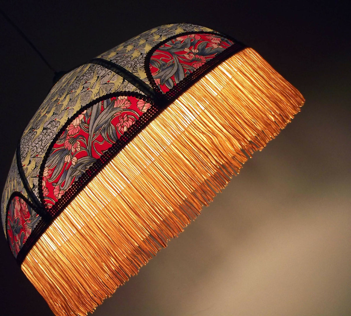 Suspension rétro inclinée : franges dorées, bande à motifs japonais et bordure noire.