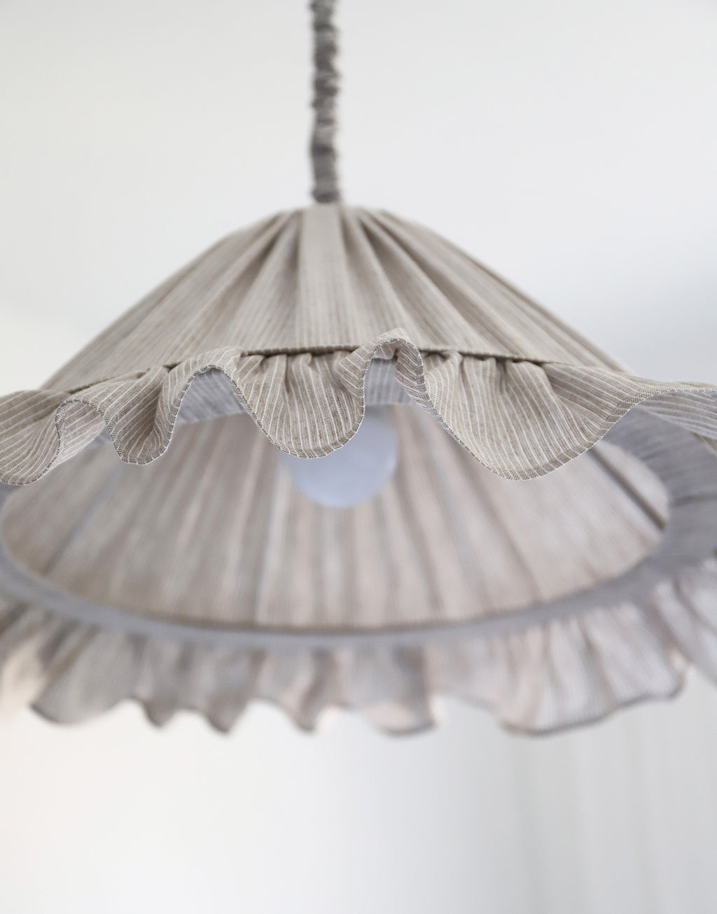 Suspension Emilia en tissu à fines rayures olive et blanches, volant plissé main, fabriquée en France par Hautlalampe