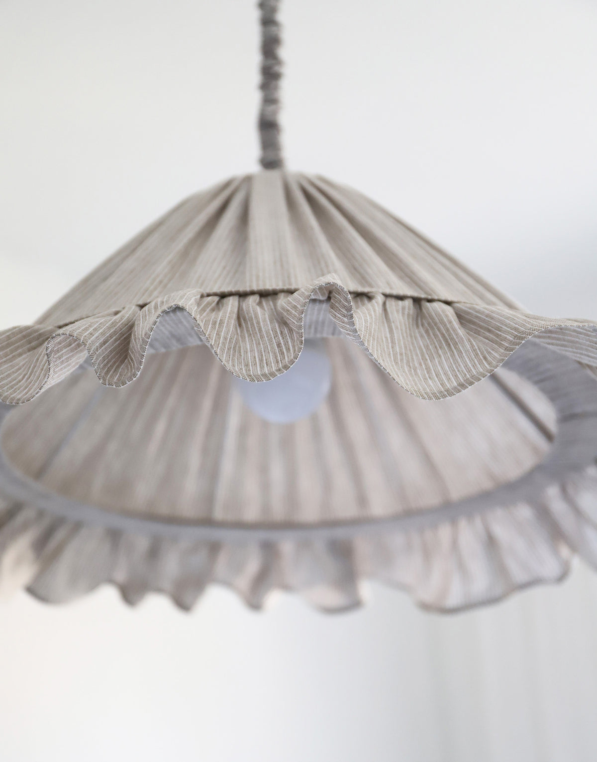 Suspension Emilia en tissu à fines rayures olive et blanches, volant plissé main, fabriquée en France par Hautlalampe