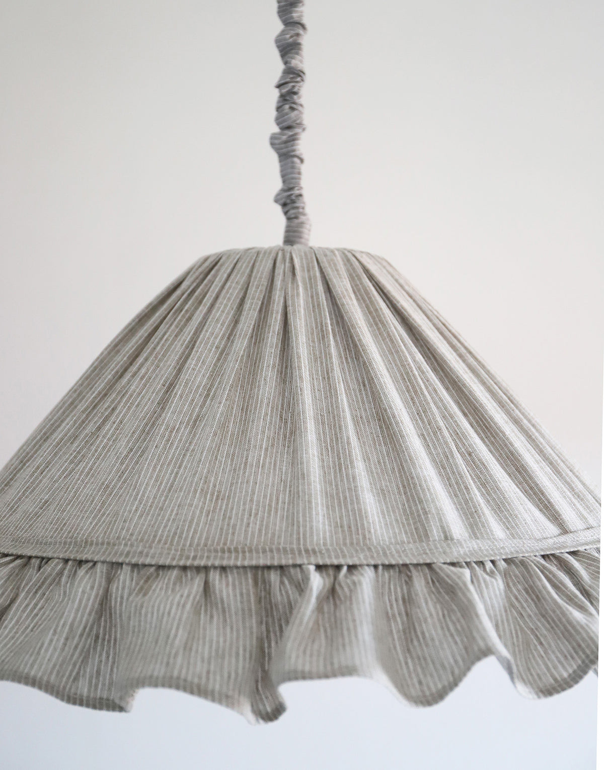 Suspension Emilia en tissu à fines rayures olive et blanches, volant plissé main, fabriquée en France par Hautlalampe