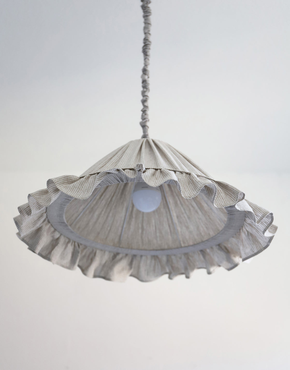 Suspension Emilia en tissu à fines rayures olive et blanches, volant plissé main, fabriquée en France par Hautlalampe