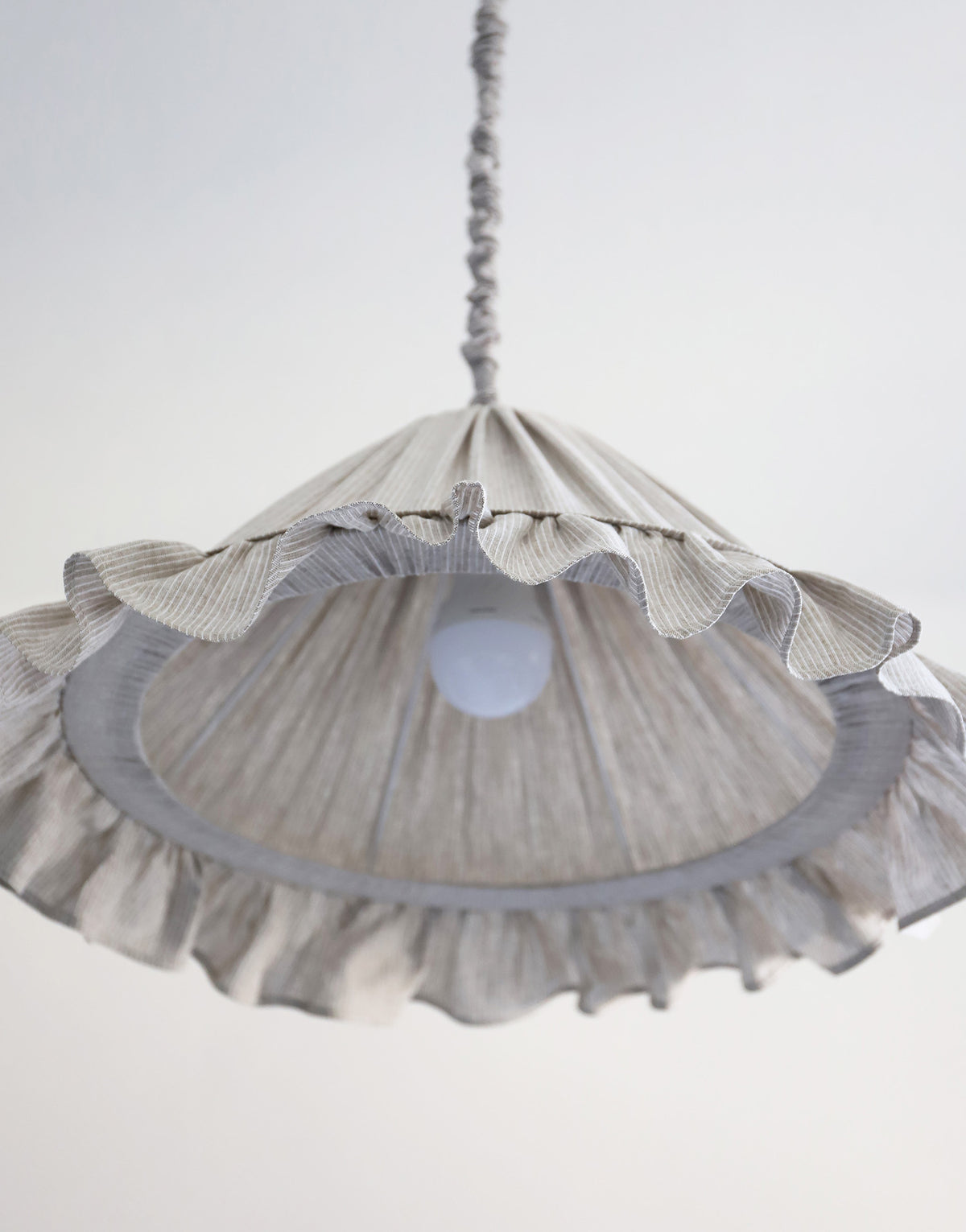 Suspension Emilia en tissu à fines rayures olive et blanches, volant plissé main, fabriquée en France par Hautlalampe