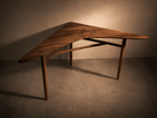 Table d’angle en bois brun, plateau trapézoïdal, pieds fuselés.